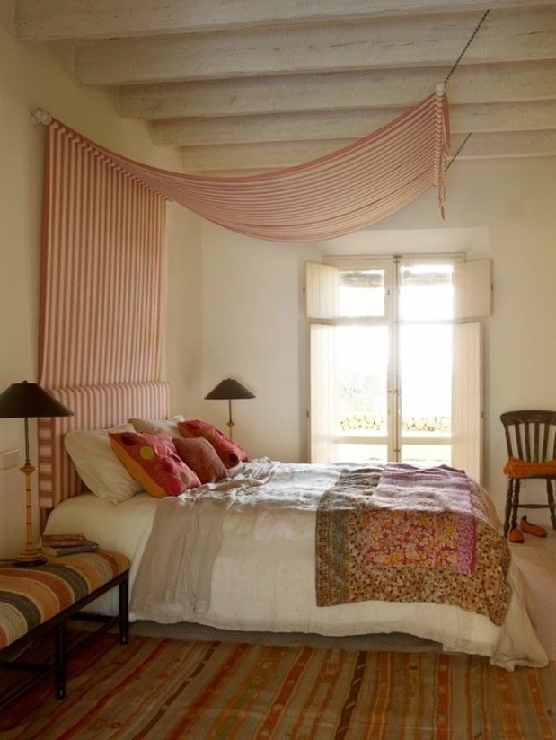 Yatağın üstüne zincirle asılan pembe çizgili canopy kumaşı.